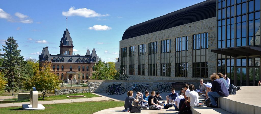 Students sit outside Regents Hall on the St. Olaf College campus