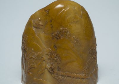 This seal serves an artistic rather than administrative purpose because its inscription is that of a poem rather than a person’s name. Notably the seal also features imagery carved on its front side, depicting the folktale of the Four Sleepers, about three Buddhist monks – Fenggan 豐干, Shide 拾得, and Hanshan 寒山 – and their friendly tiger, who together symbolize ideas of peace, calm contemplation, and meditation. In the top-right quadrant is the lead monk Fenggan, a physically distinct character known for using the tiger as his steed. In the bottom-right quadrant is the back view of a sleeping monk, with a straw hat leaning against him. In the bottom-left quadrant is a lounging tiger, with a monk laying alongside it. Of these two monks, it is hard to tell which is Shide or Hanshan – they are often depicted as nearly identical. In the top-left quadrant is a traditional incense burner from which smoke curls upwards. The burning of incense in Buddhist practice symbolizes purification, especially of the area where it is being burned. The translation of the text on the bottom reads: “the sea of suffering is boundless, in repentance there is salvation.”