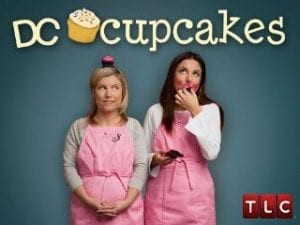 An advertisement for D.C. Cupcakes with two women wearing pink aprons. 