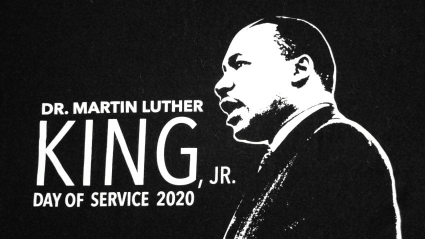 A black poster with an outline of Martin Luther King, Jr., with the words "Dr. Martin Luther King, Jr. Day of Service 2020"