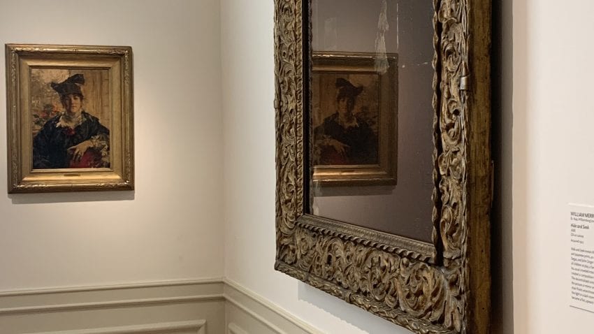 Two paintings in the corner of a room.
