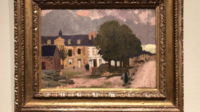 A framed painting with a brick building on the left and a tall tree on the right side