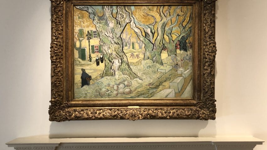 A framed painting with a three large trees with vast branches 