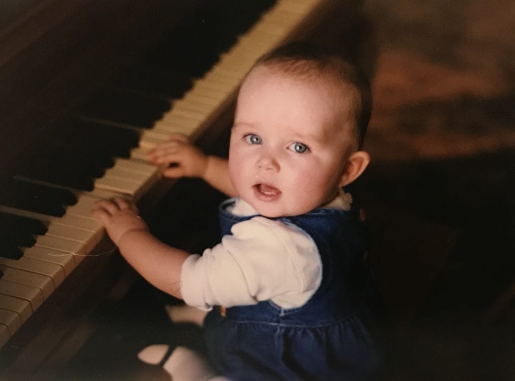 A baby plays a piano. 