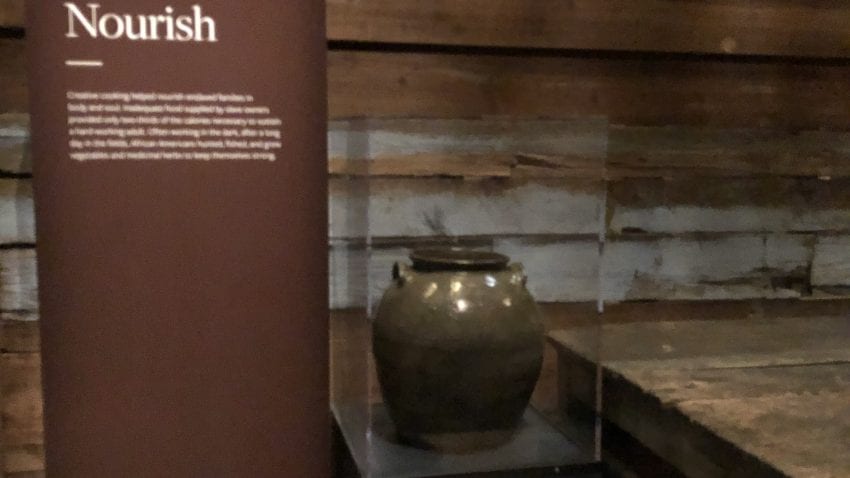 A gray pot sits besides a description of the pot in a brown poster