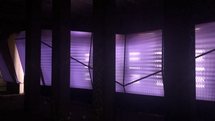 A purple art piece with lights brightening the installation. 