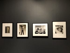 A black wall with four small framed photos. 