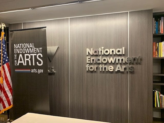 A gray wall with the words National Endowment for the Arts