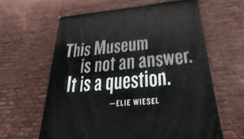 A black banner reading "This museum is not an answer. It is a question."