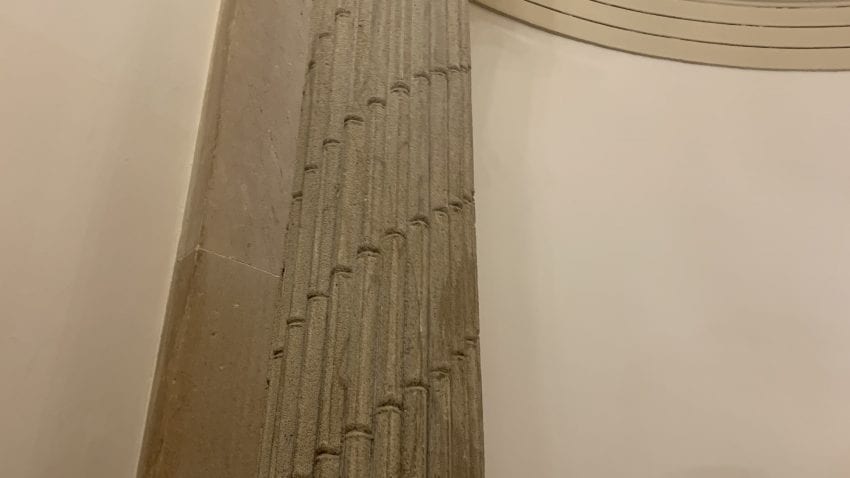 A pillar in a tan alcove wall.
