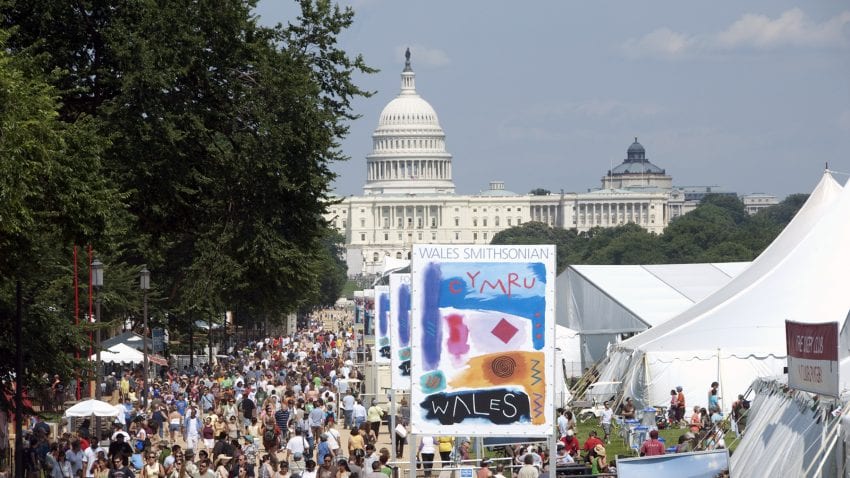 The United States Capitol building across the National Mall full of people, white tents, and posters.