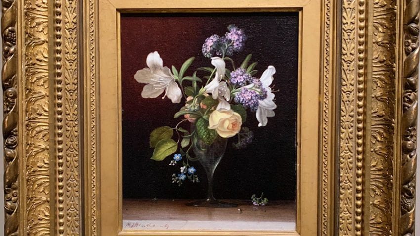 A framed painting of flowers with a black background. 
