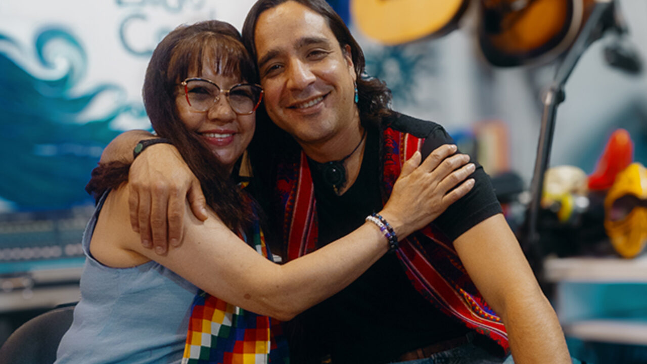 A latina woman hugging a latino guy.