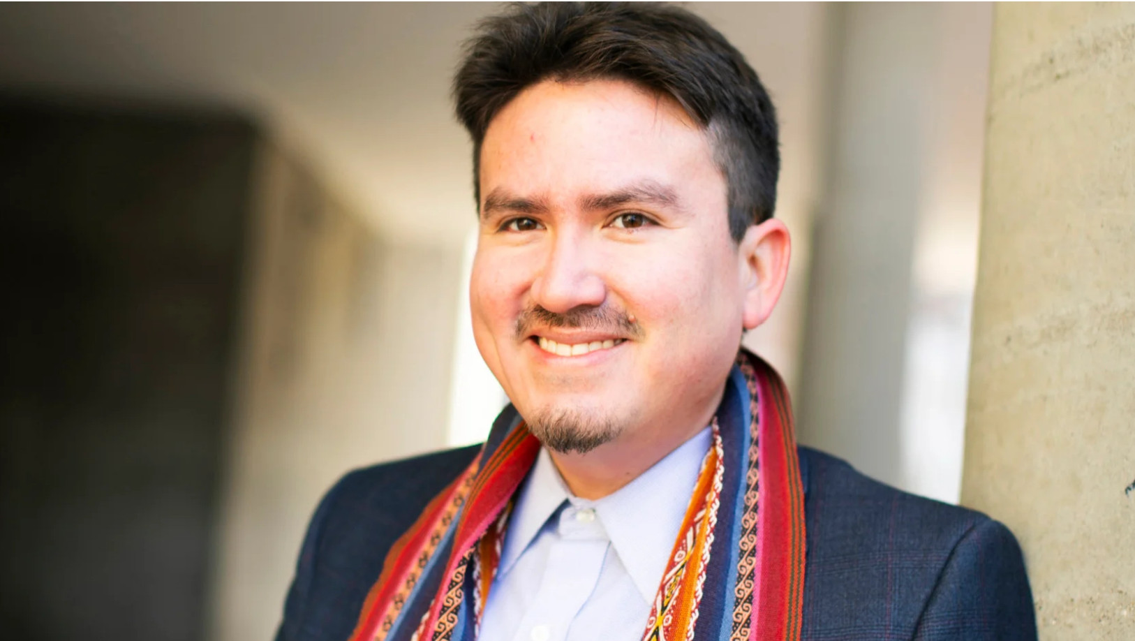 Latino guy smiling in front of a camera