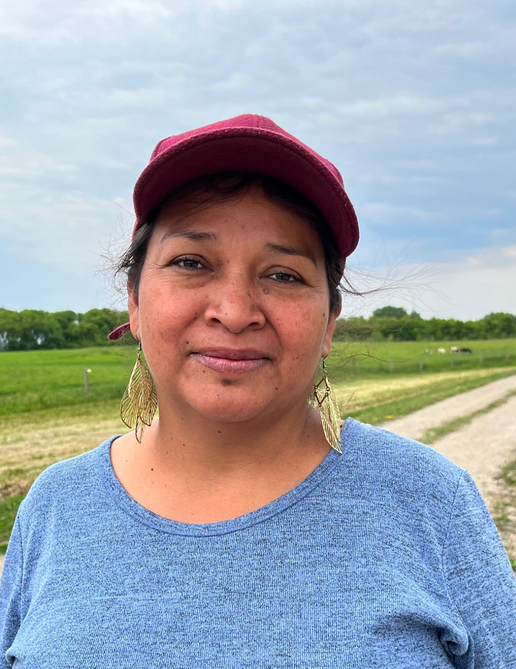 Latina lady with blue shirt and red cap
