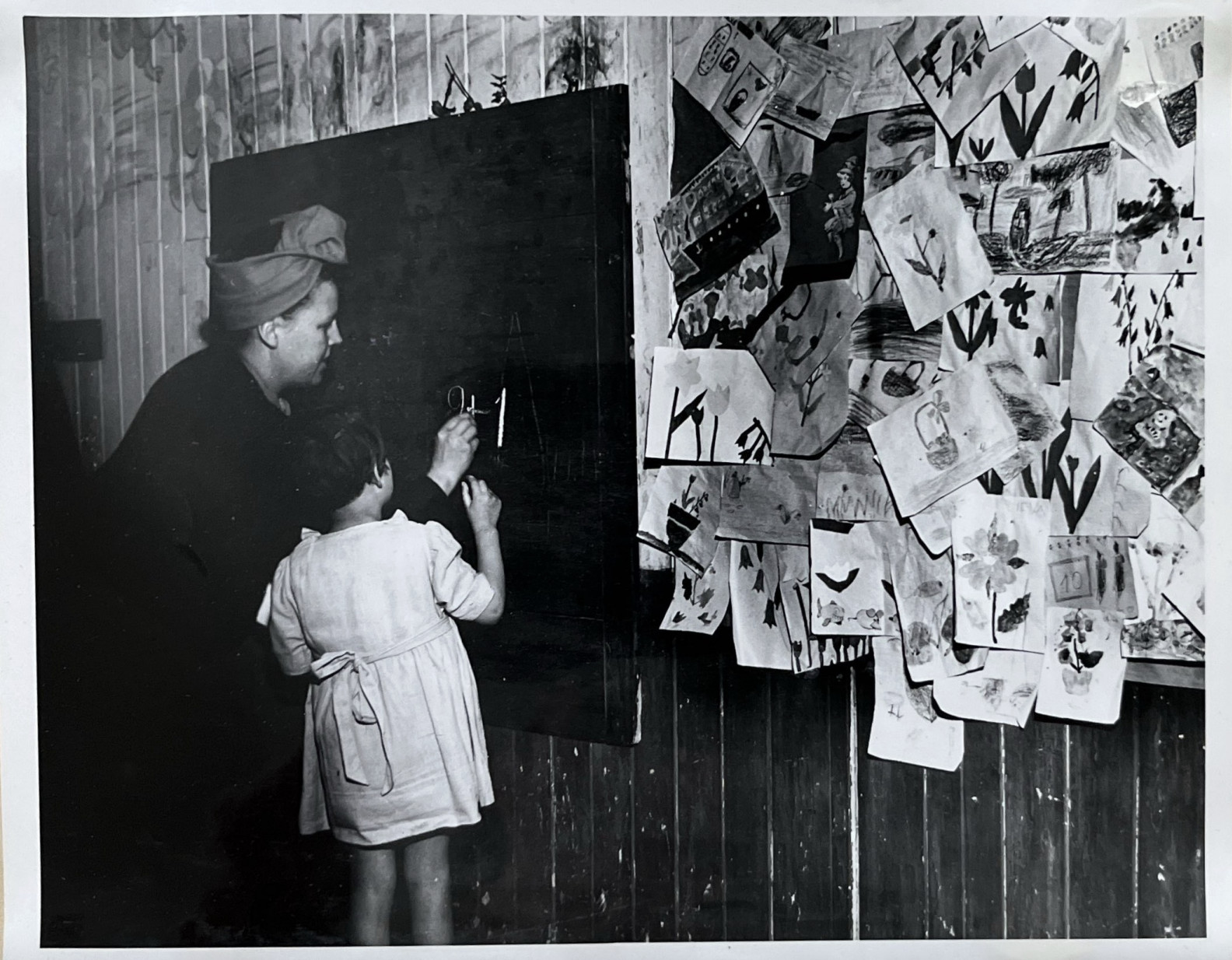 Screenshot 2026-06-30 at 10.33.53 AM woman and child in front of children's artwork