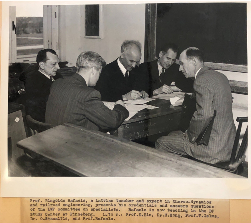 Dr. Hong interviewing Displaced Intellectual with other Displaced scholars. Original Caption: "Prof. Ringolds Rafaels, a Latvian teacher and expert in thermo-dynamics and railroad engineering, presents his credentials and answers questions of the LWF committee on specialists. Rafaels is now teaching in the DP Study Center at Pinneburg. L. to r.: Prof. E. Ein, Dr. H. Hong, Prof T. Celms,, Dr. O. Stanaitis, and Prof. Rafaels."