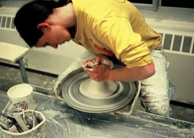 Student throwing pottery.