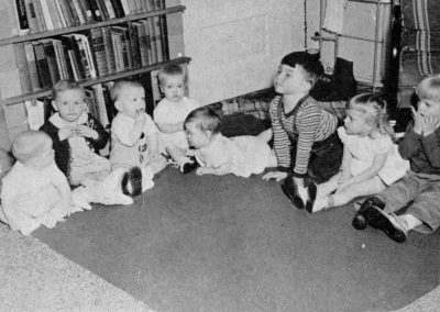 Children sitting in a circle inside.