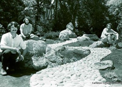 Workers sitting by Japanese Garden's rock path.